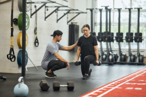 Personal Training client doing a lunge with Personal Trainer guidance